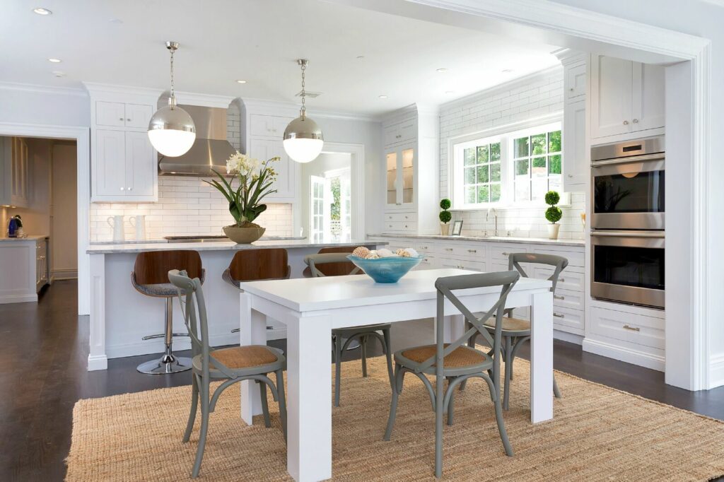 A Bright Kitchen Featuring White Cabinets and a Wooden Table