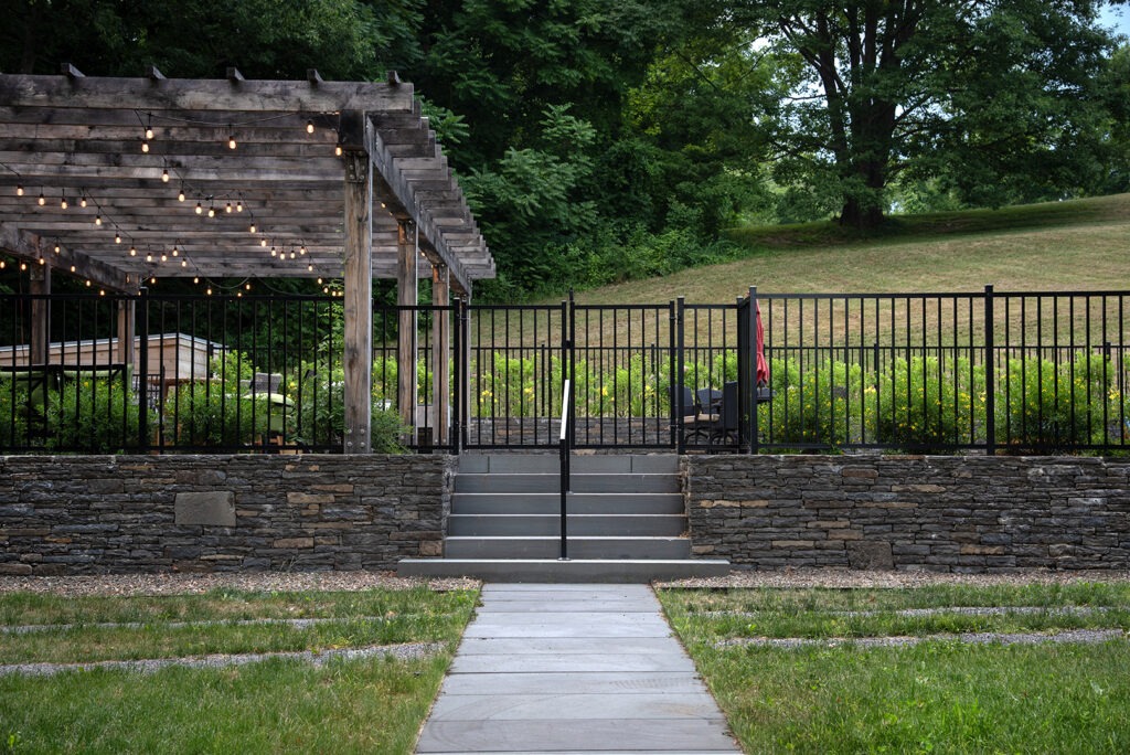 A Serene Pathway Leading to a Pergola-Covered Fence