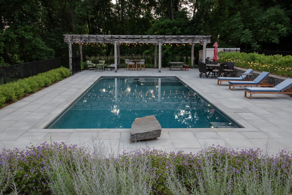 A Serene Backyard Pool Featuring a Pergola and Comfortable Lounge Chairs for Relaxation and Leisure