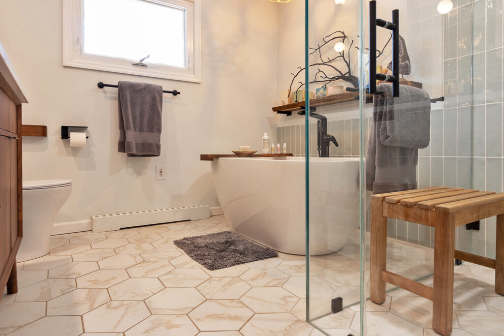 A Modern Bathroom Featuring a Glass Shower Door and a Wooden Stool