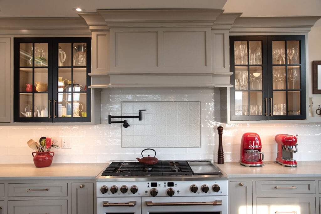 oven range area with red appliances and window cabinets