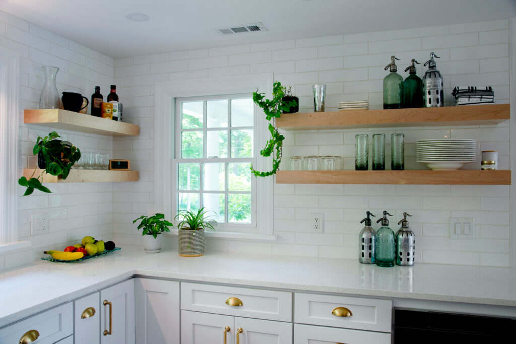 white kitchen with subway brick walls and open wood wall shelving