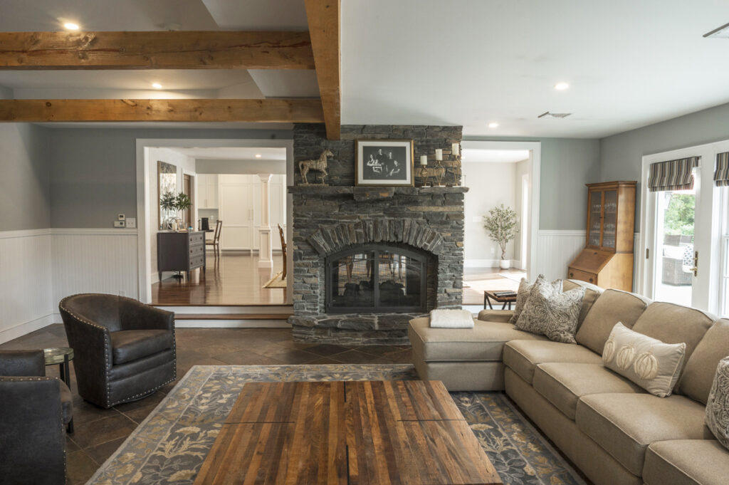 Living room with a stone fireplace and exposed wood beams